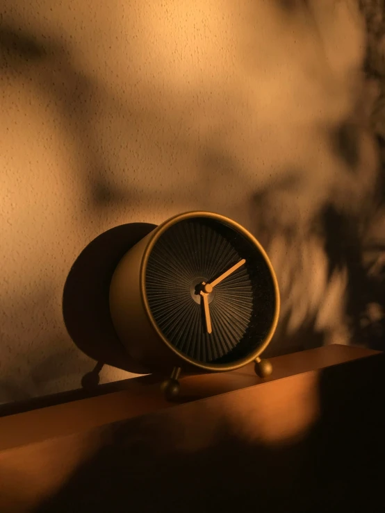 a clock on a shelf in the dark
