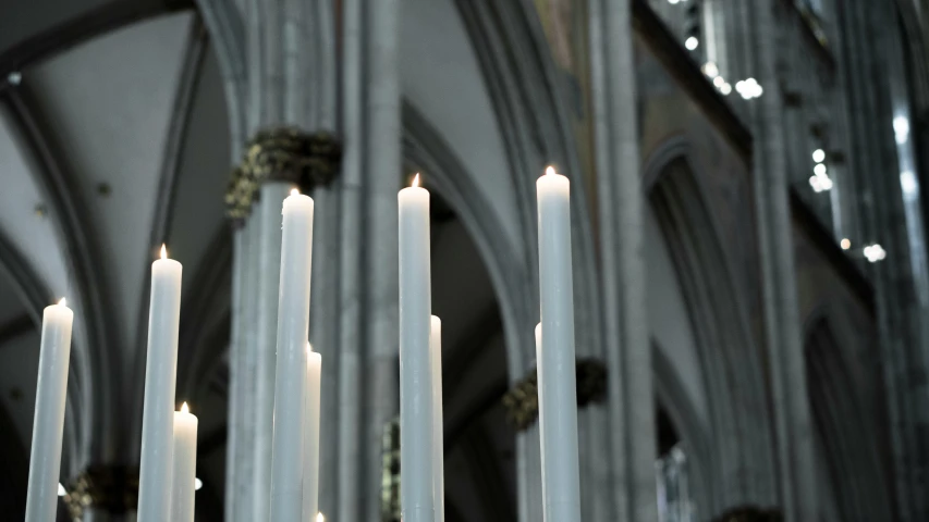 a bunch of white candles in front of a tall building