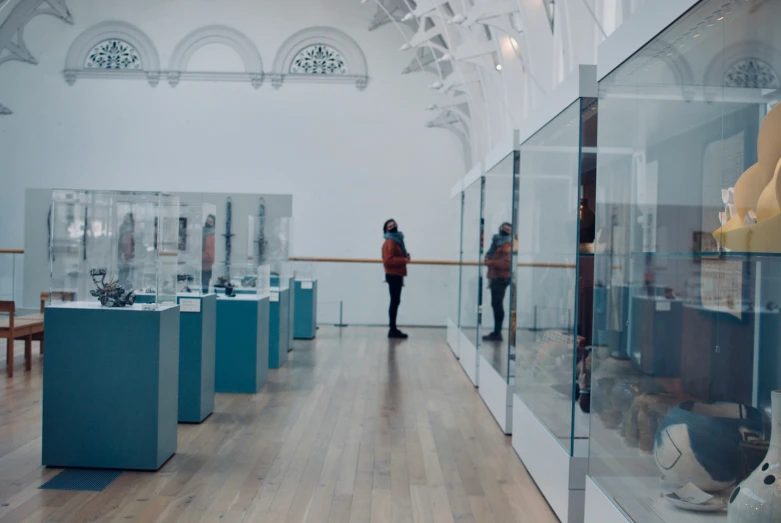 two people standing in a large room with glass walls