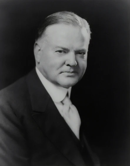 a black and white po of a man in suit and tie