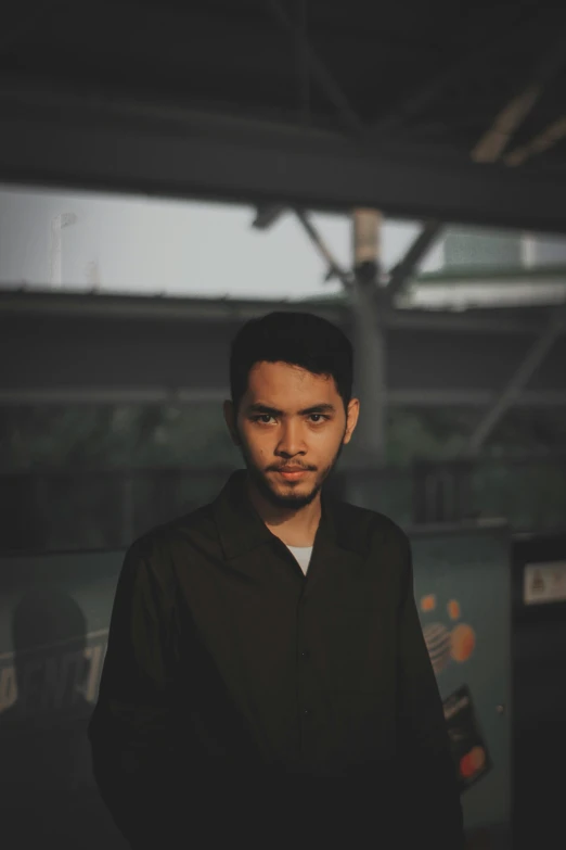 a man wearing a black shirt standing underneath a roof