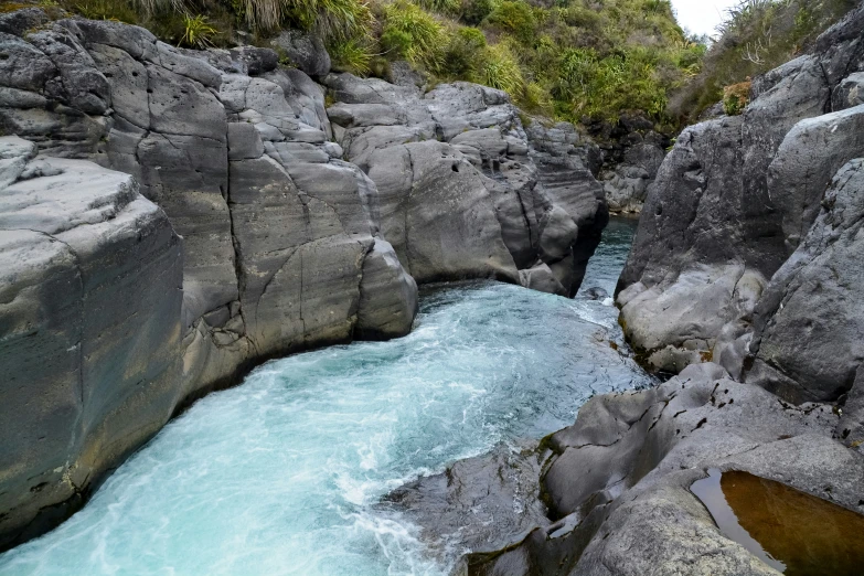 a rocky stream flows between some big rocks