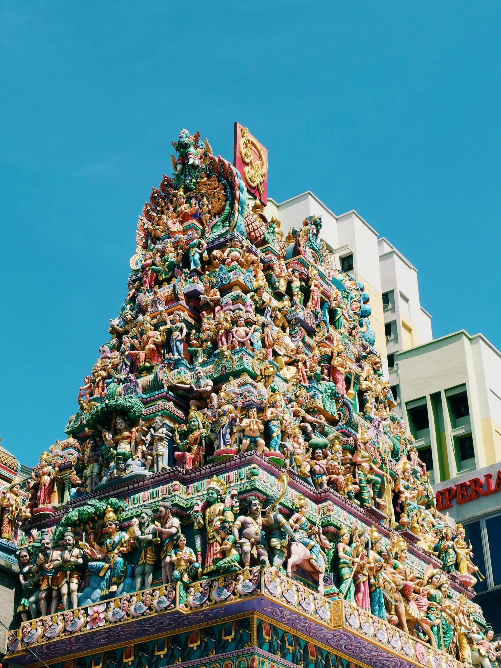 a very tall colorful and ornate structure with buildings in the background