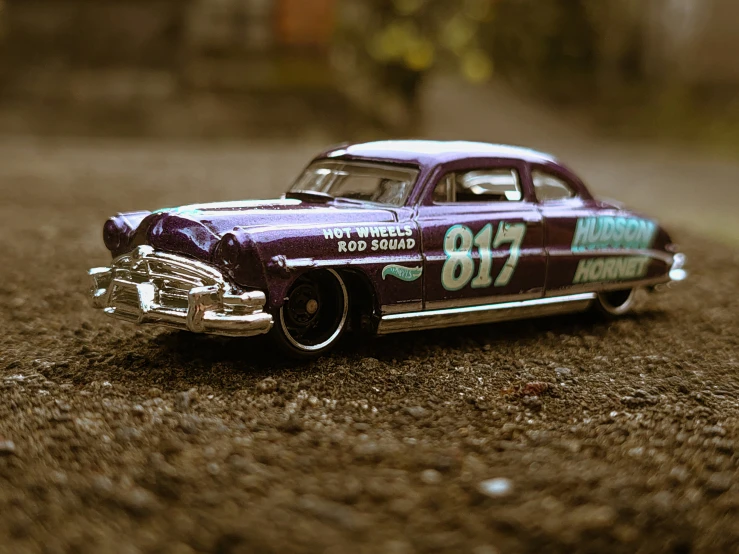 a car on a dirt road next to a leafless tree