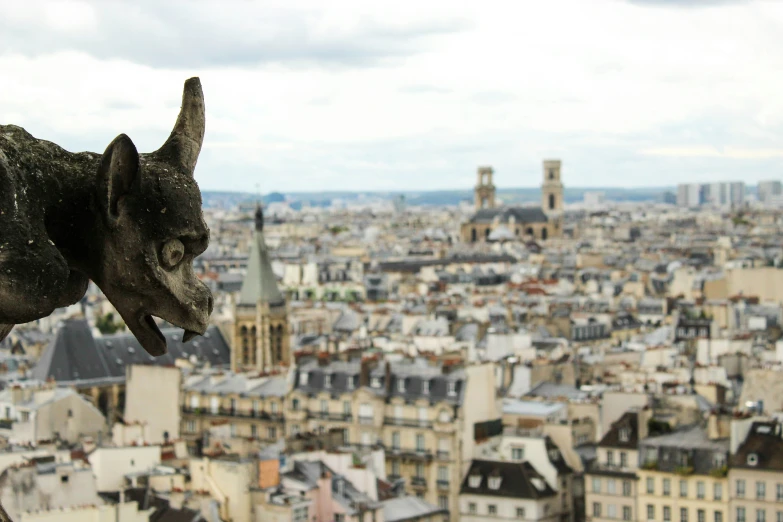 a dog statue is overlooking the city with its ears sticking out