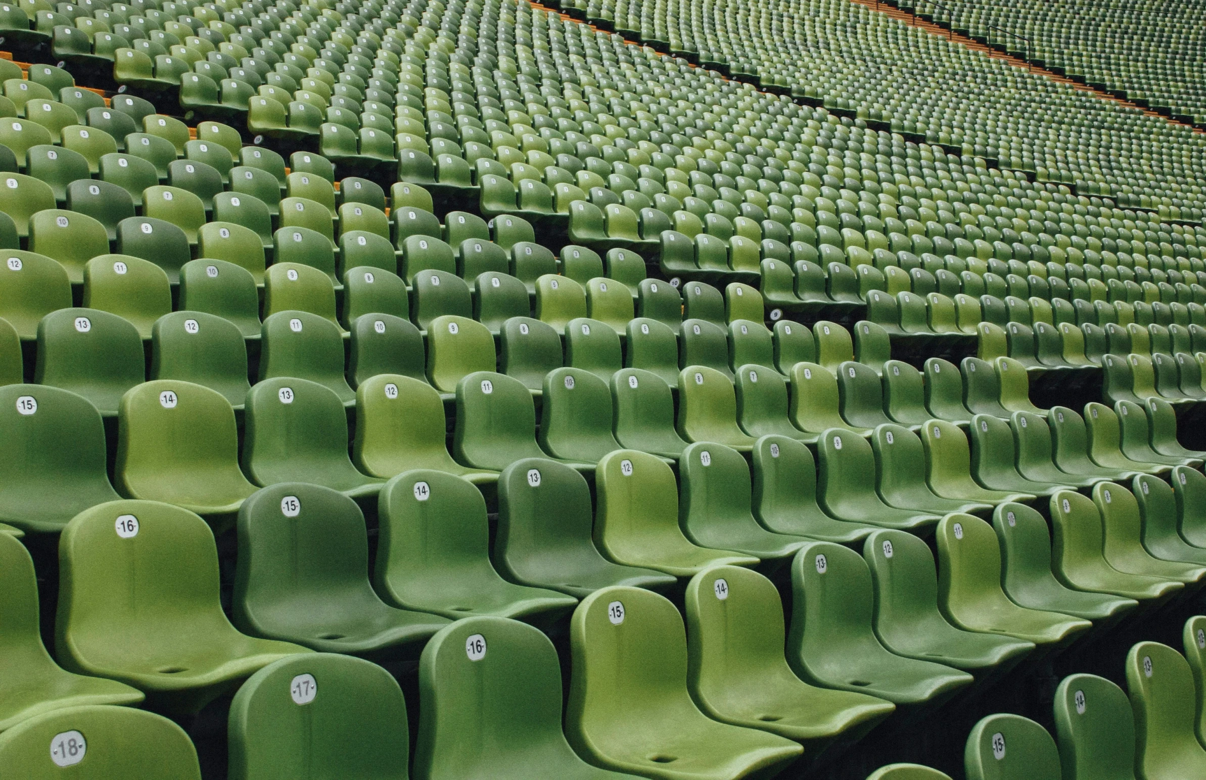 rows of empty stadium seats sitting inside an arena