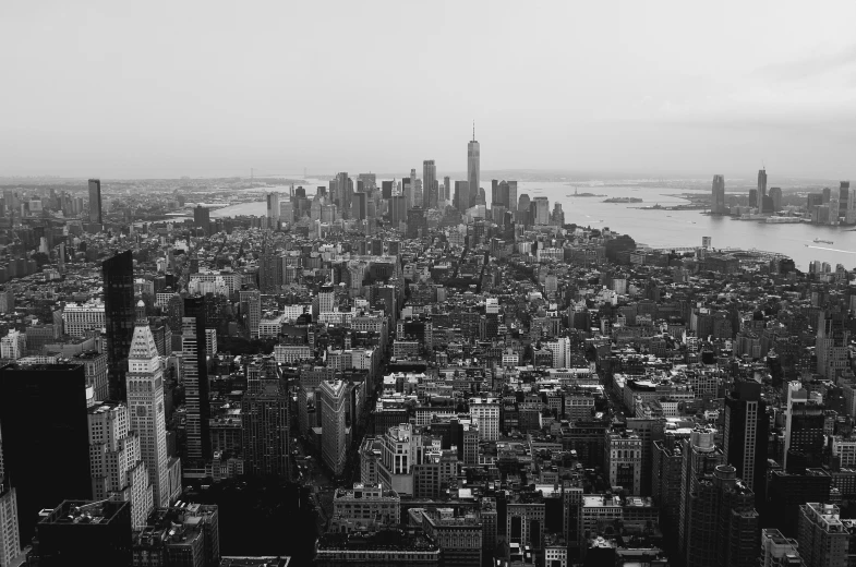 a cityscape has tall buildings and large lake in the distance