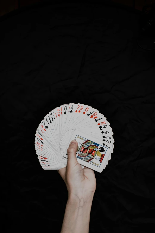 a person holding four card game in their hand