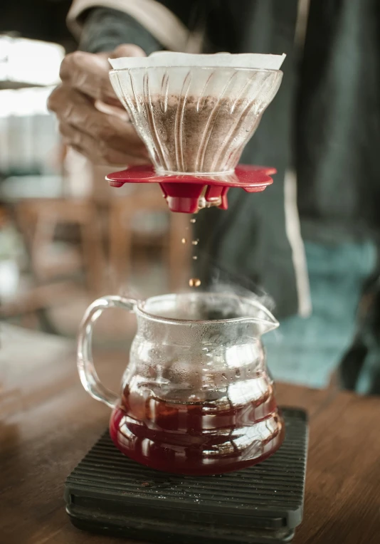 the coffee is poured from a carafe with its red handle