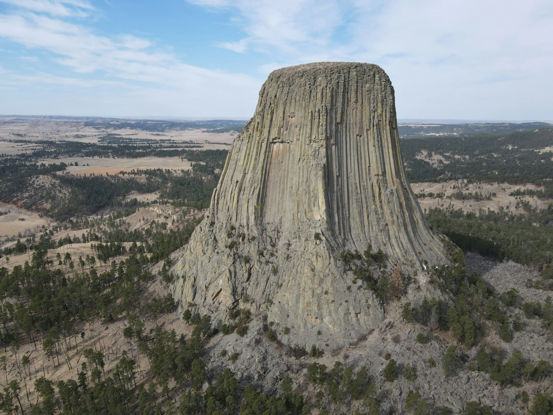 a large rock formation sitting next to trees on top of a hill