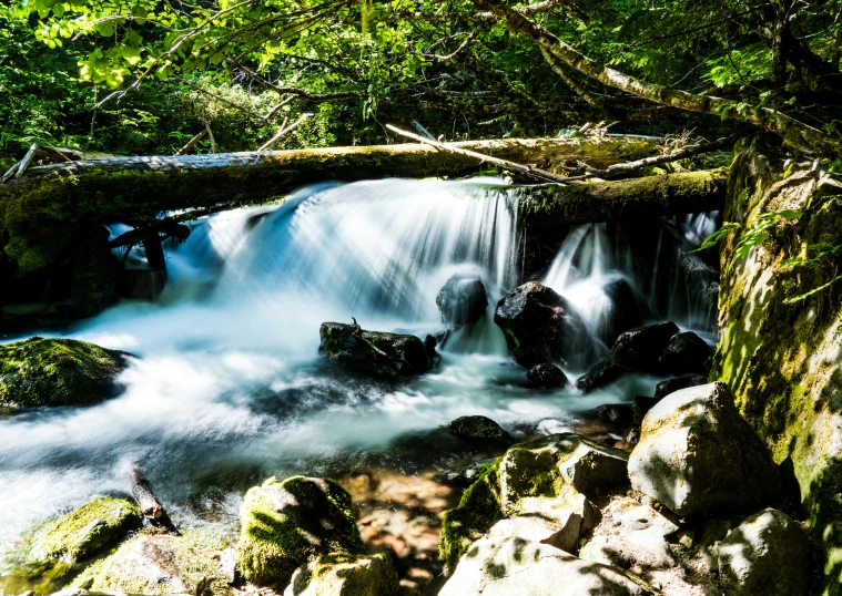 a stream is flowing from the ground next to some rocks