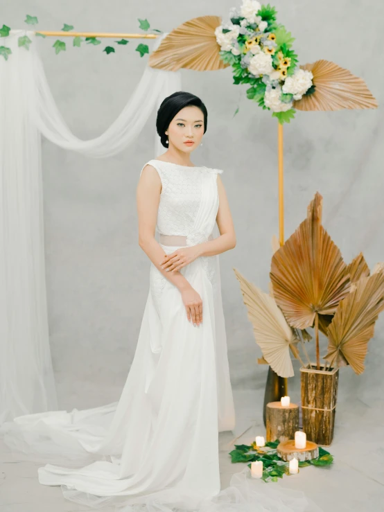 woman in white dress and flower arrangement by candle