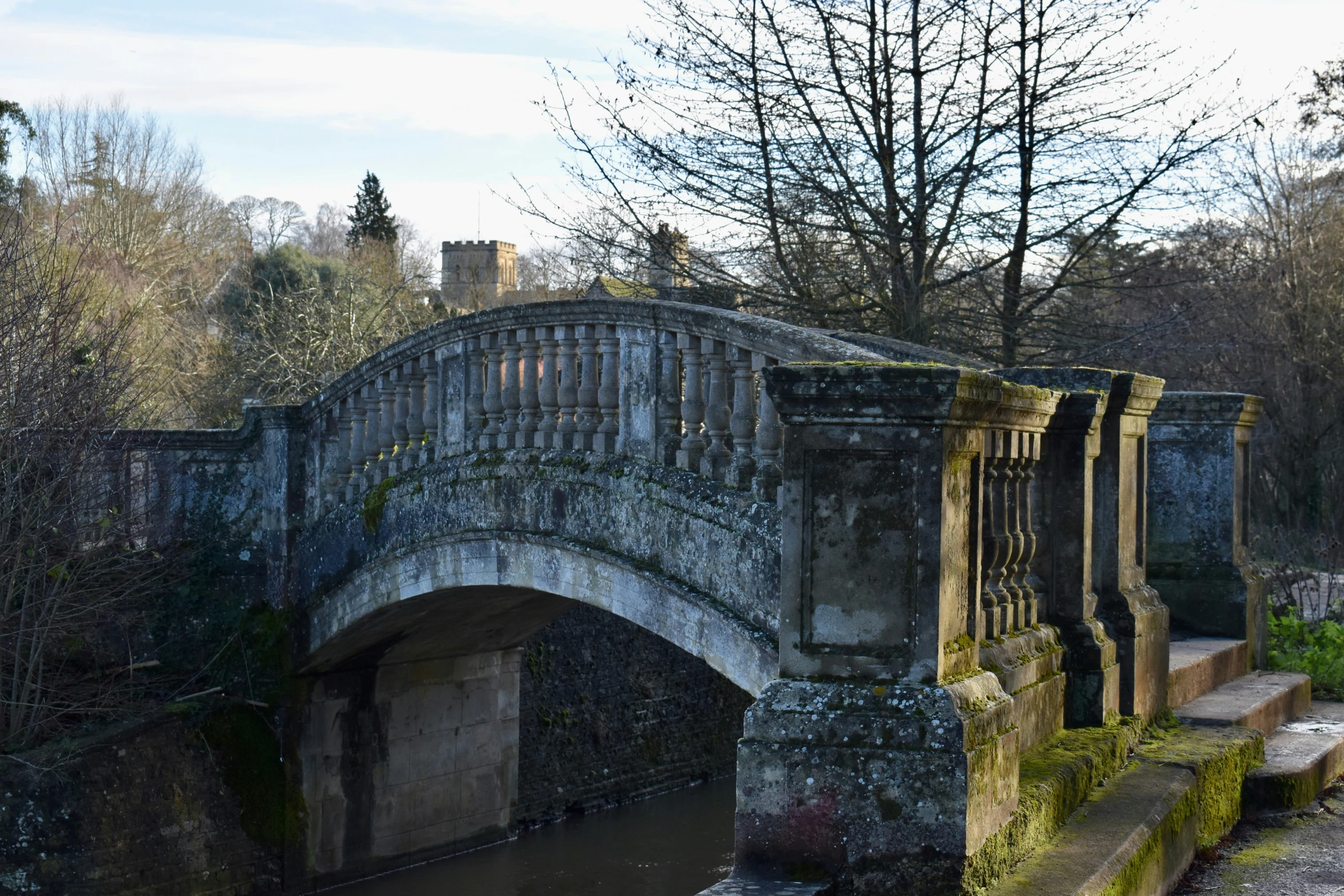 an old bridge in a city next to the water