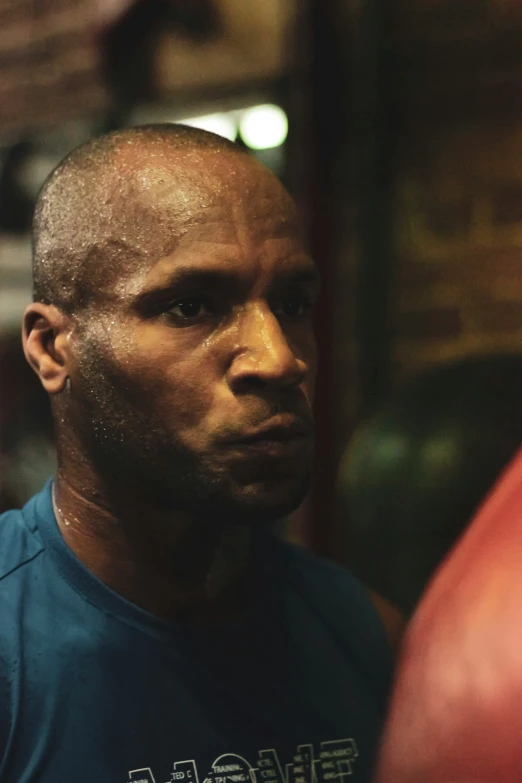 a man with a bald head standing near red punching punching gloves