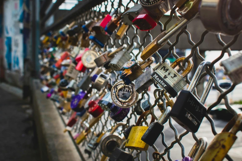 a bunch of padlocks are attached to a fence