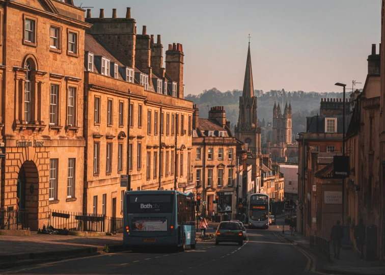 city buildings line an empty street with some traffic on the road