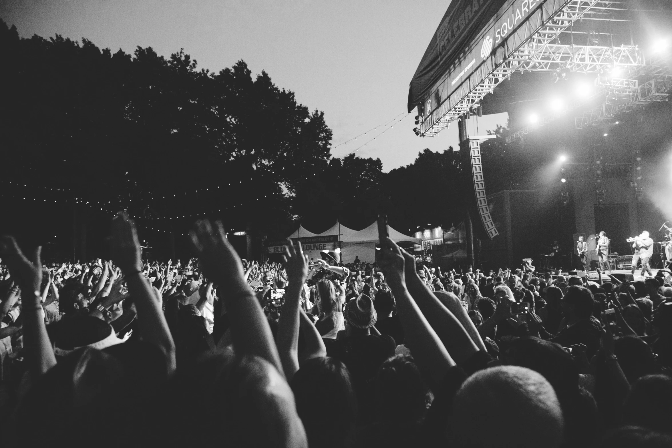 a group of people are standing around and holding up their hands