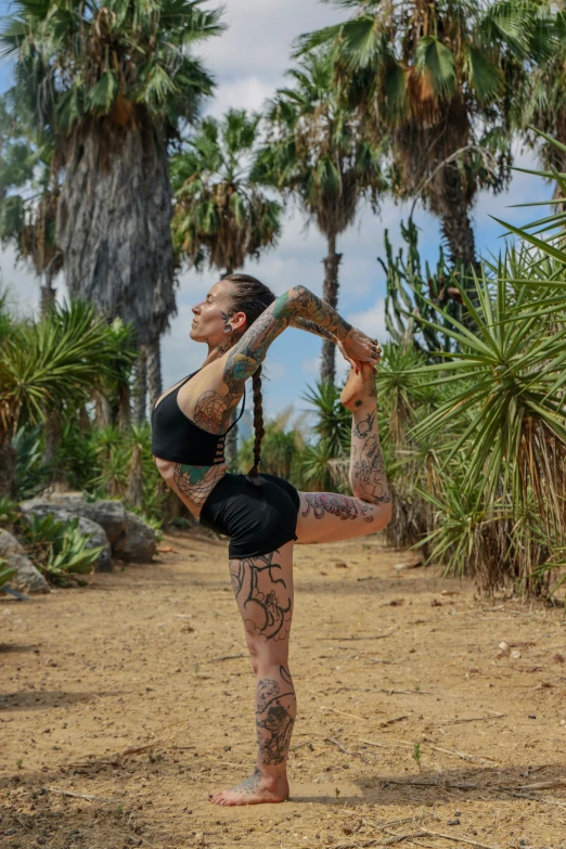 a tattooed woman doing a back flip on her belly