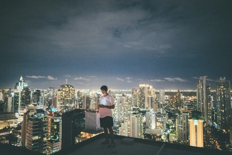 a man standing on top of a building next to the city