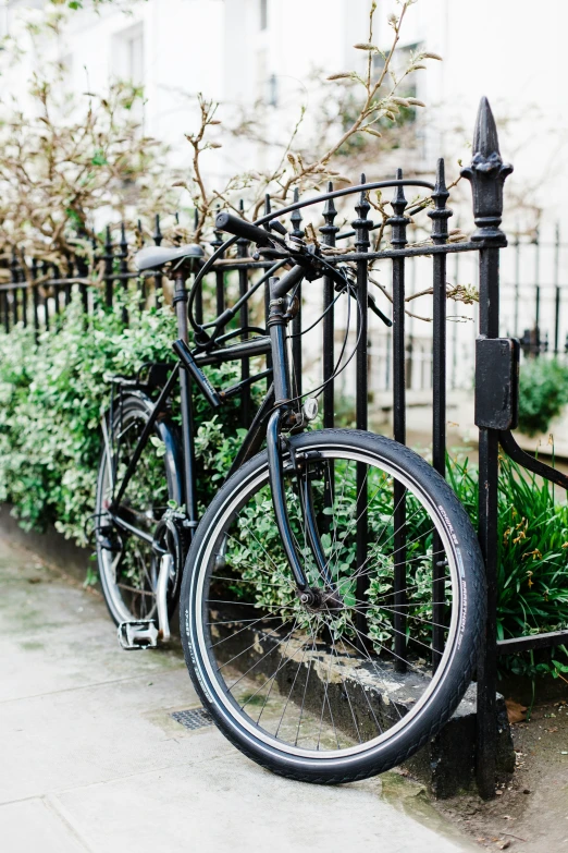 a bike is  to the iron fence