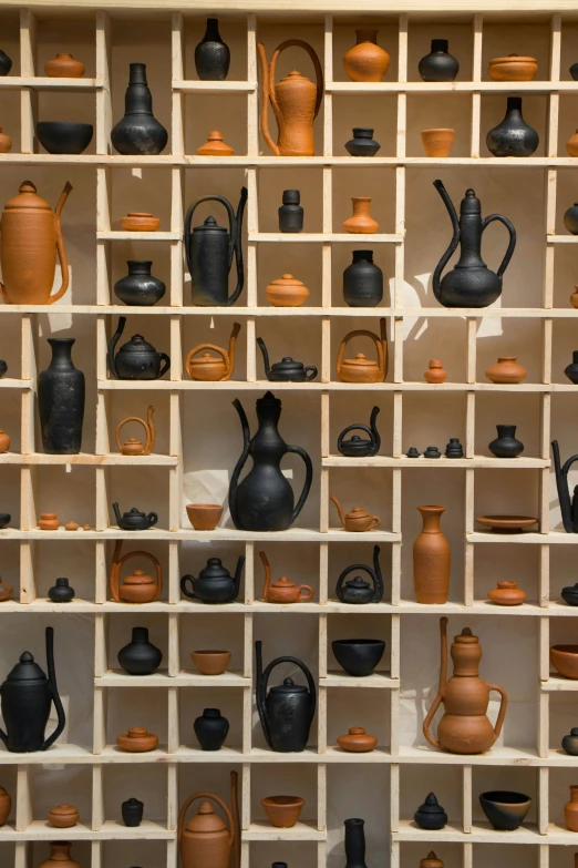 a shelf is filled with small vases and pots