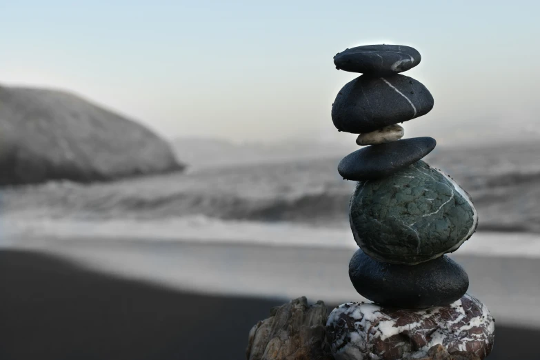 a pile of stacked rocks next to a body of water