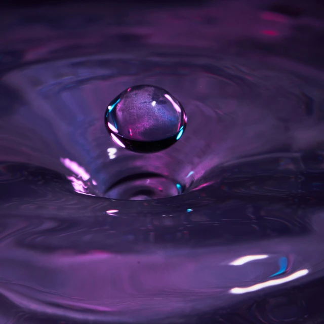 a round drop in water, with reflections