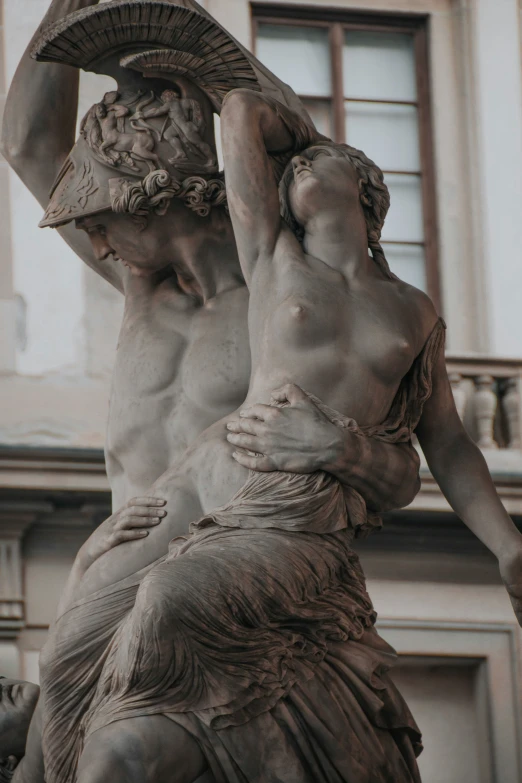 the statue in front of a building shows a woman carrying an umbrella