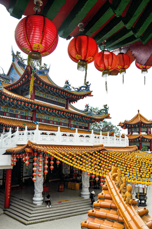 several red lanterns hanging from the roof of an oriental building