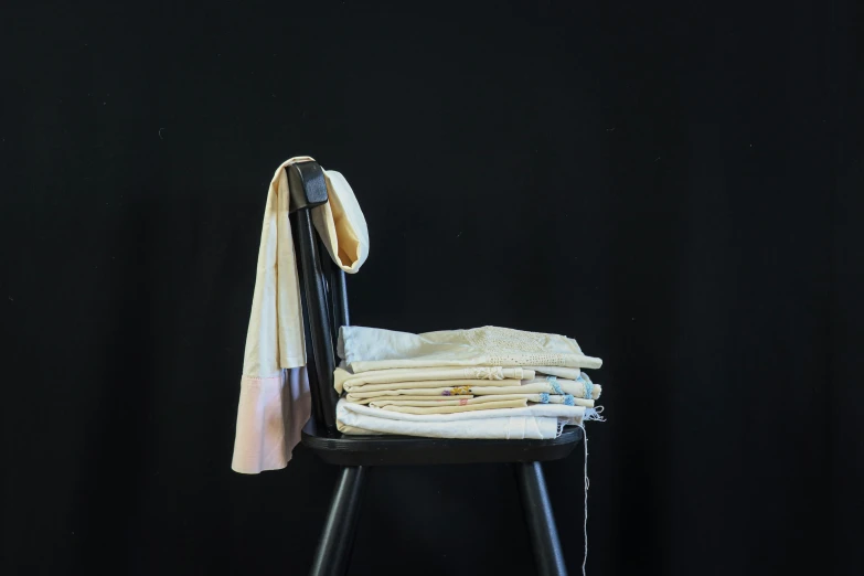 a stack of folded clothes on a chair