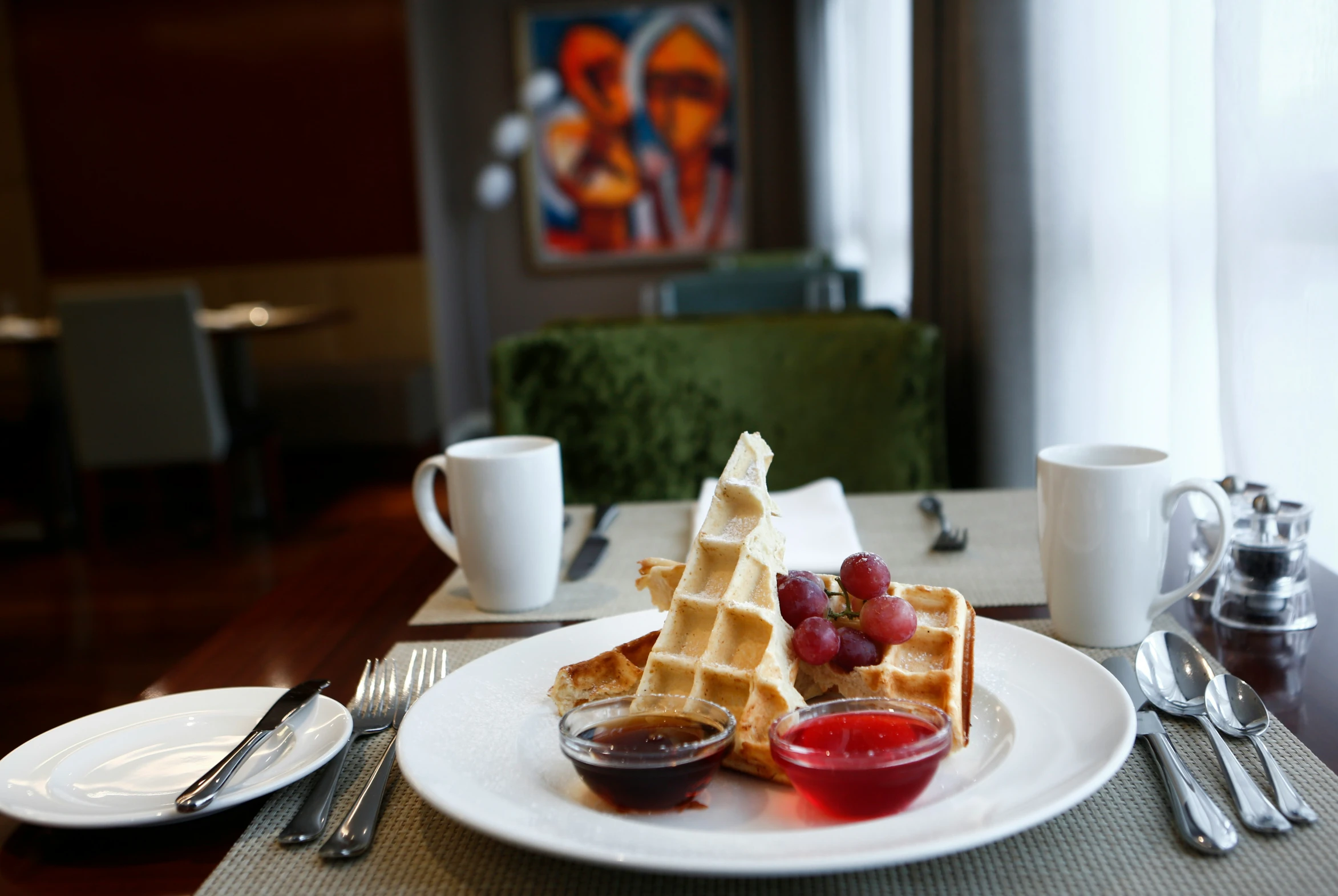 a plate with waffles and fruit is ready to be eaten