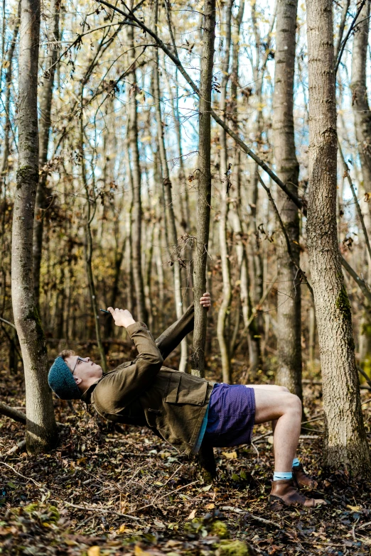 a man is lying down in a wooded area