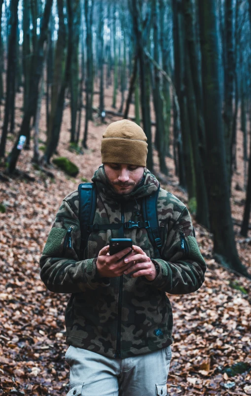 a man with a hat on looking at his phone