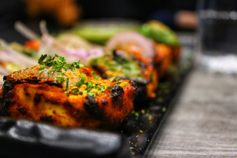 grilled meats with a side of vegetables are sitting on a plate