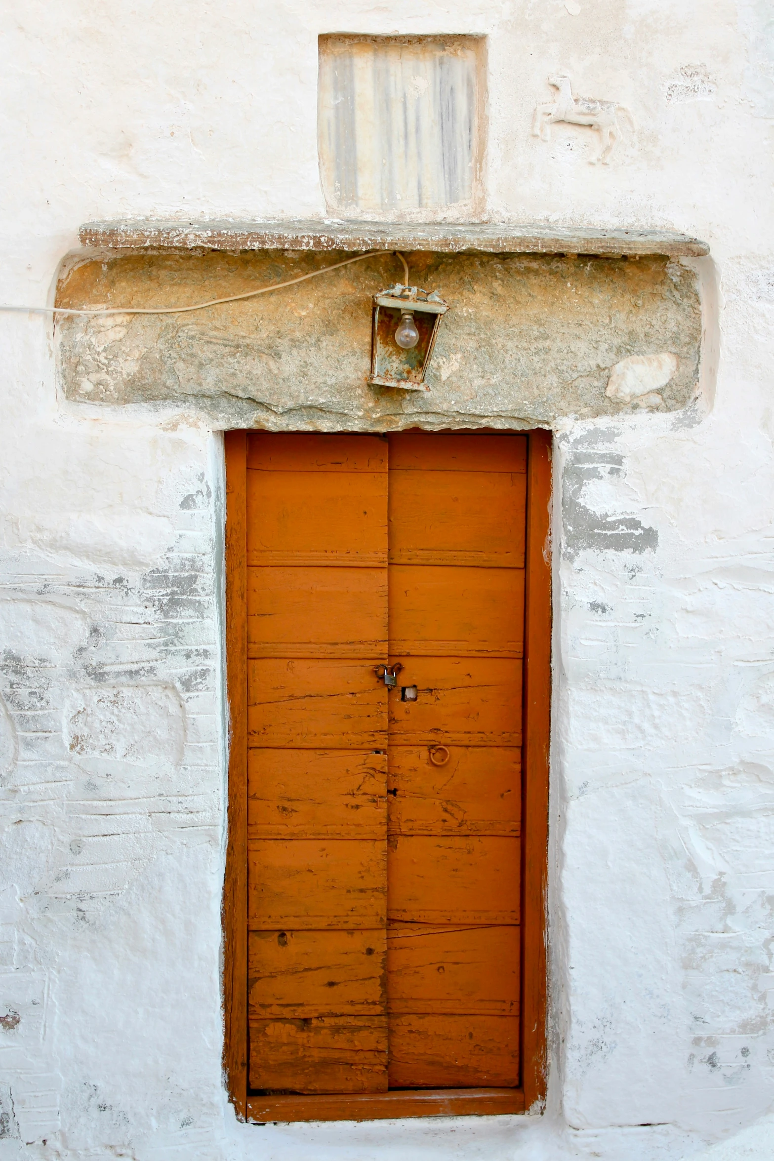 an old door is closed on the side of a white building