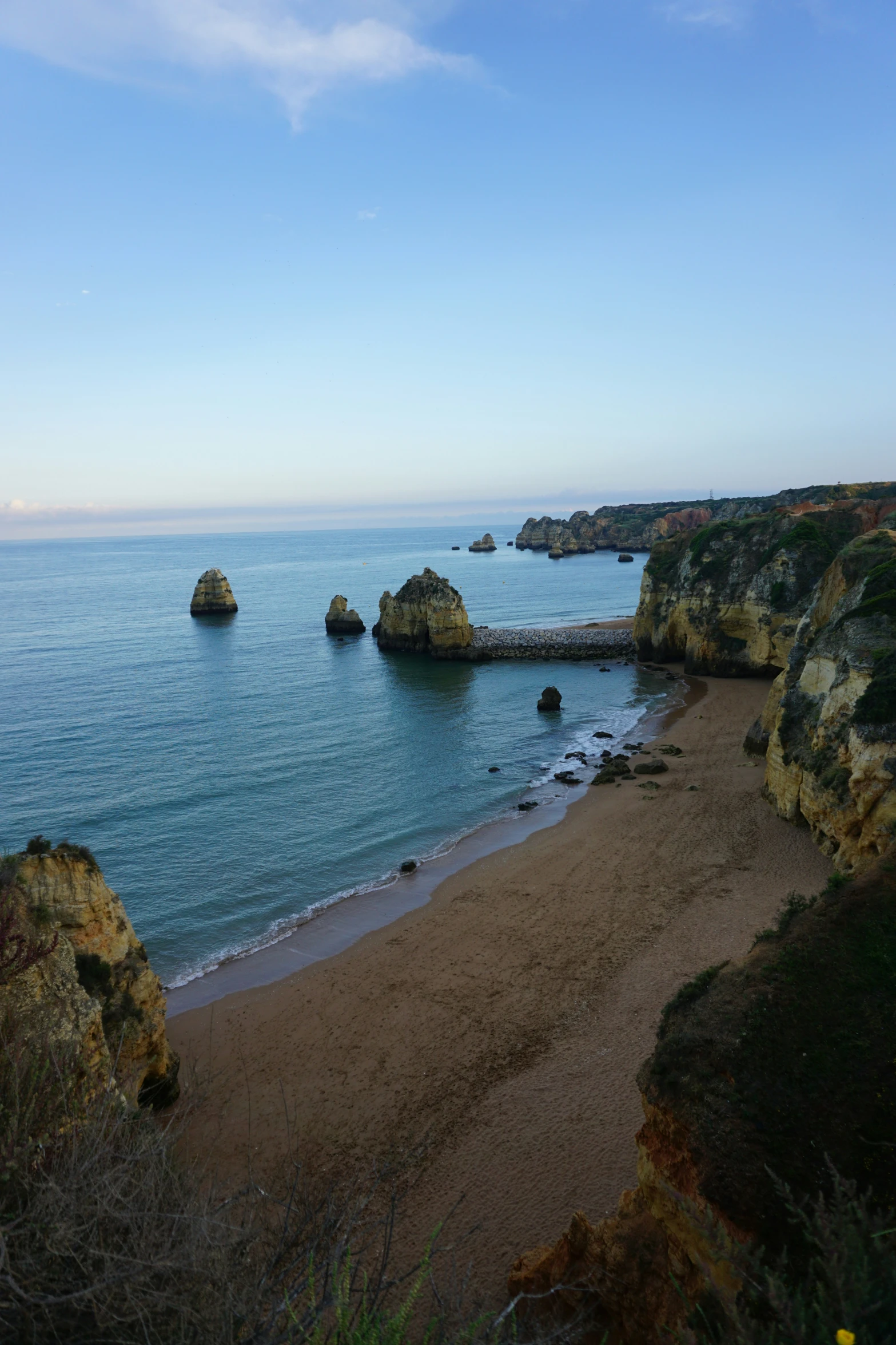 an ocean beach with rocks sticking out of the water