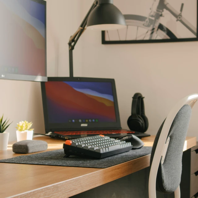 a computer on a desk with headphones and a mouse