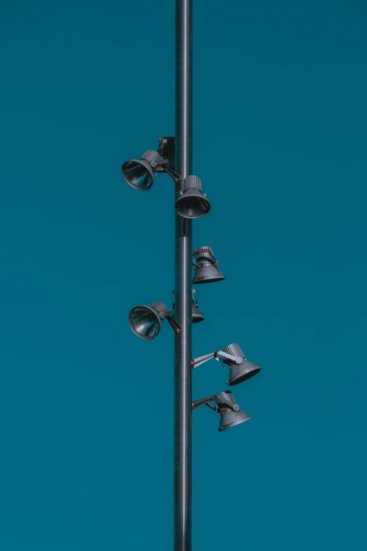 a metal pole is sitting against the sky with four lights
