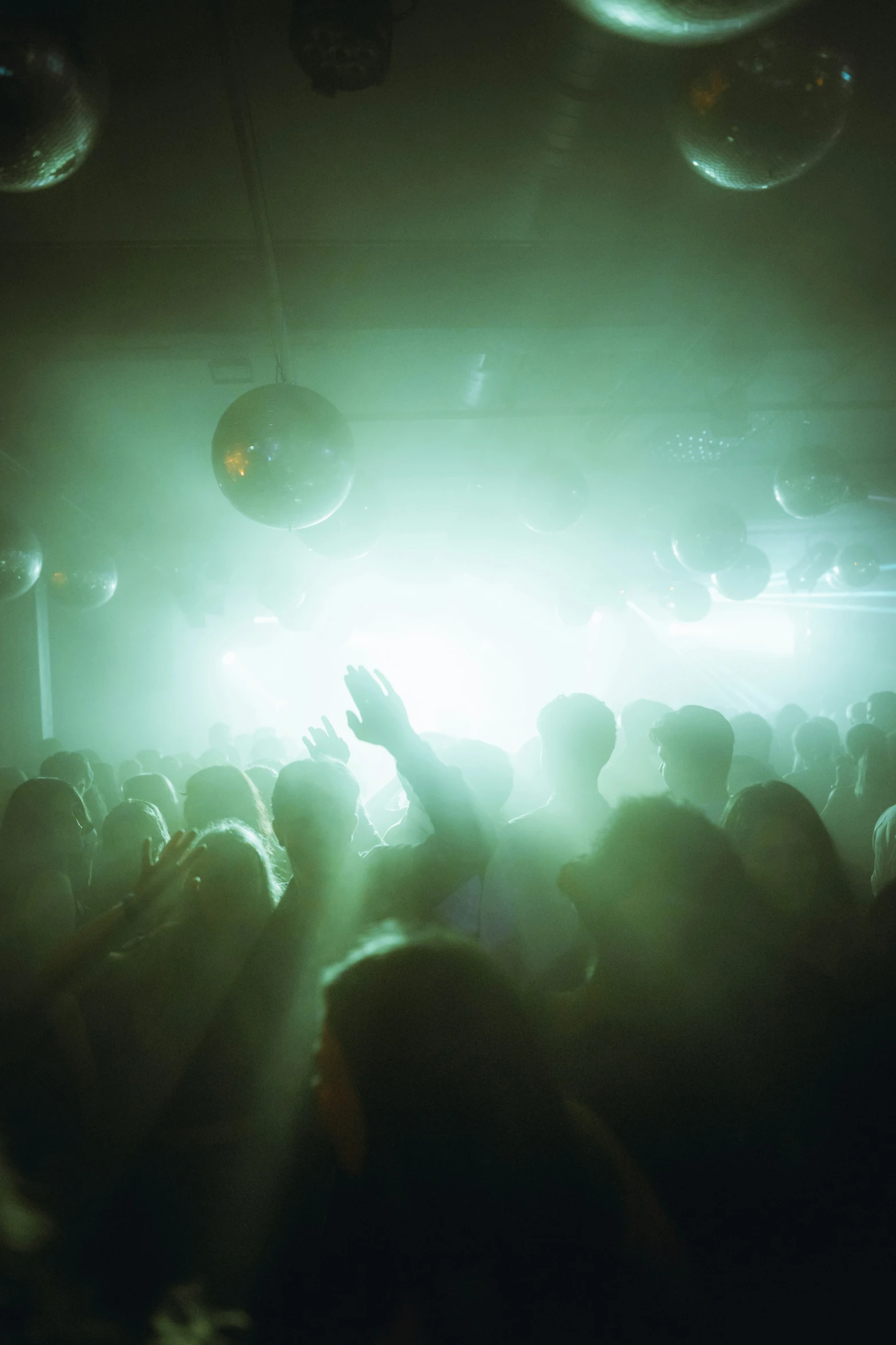 a crowd is in a dimly lit club watching a performance