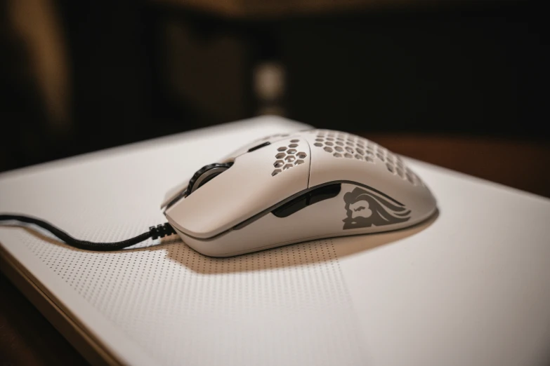 a white computer mouse with black tips is shown on a desk