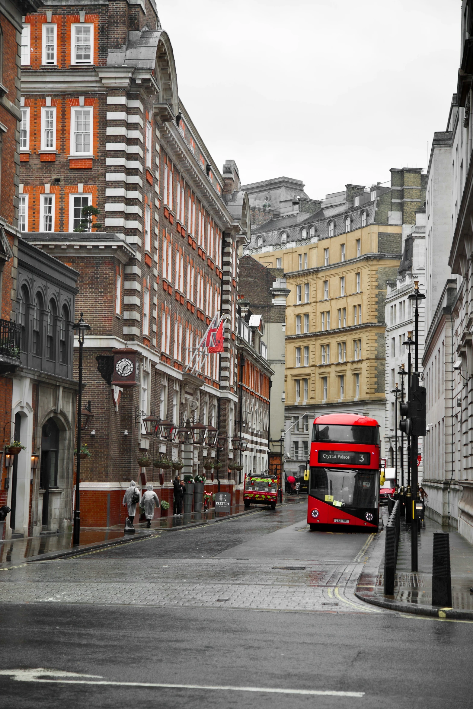 a big red bus driving through some buildings