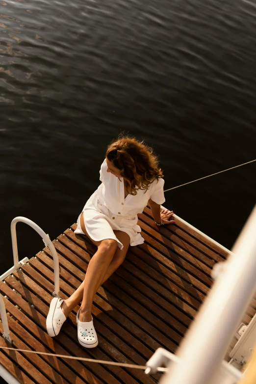 the woman is sitting on a boat looking over the railing