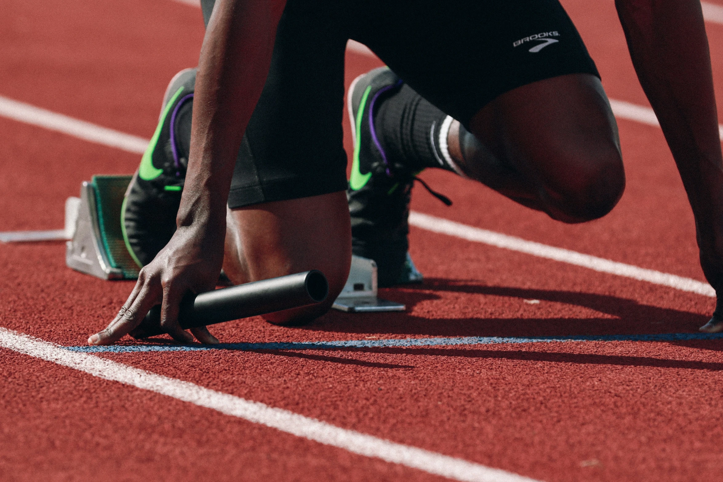 two legs with one foot on the ground on a track