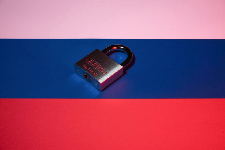 a padlock sitting on the side of a blue and red surface