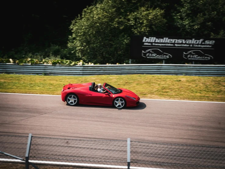 a red car driving down a race track