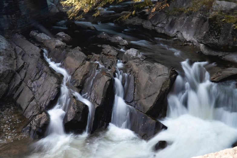 some water falling over some rocks into some creek