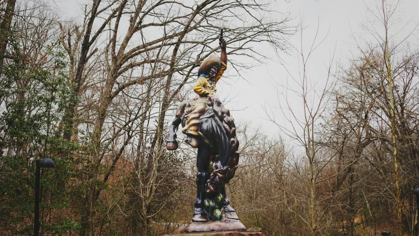 there is a large statue of a man standing in the woods