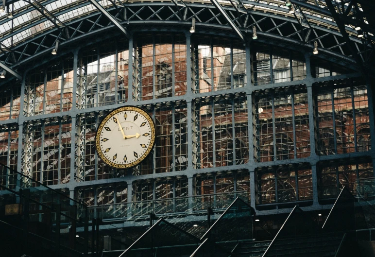 a clock in a subway station with metal railings
