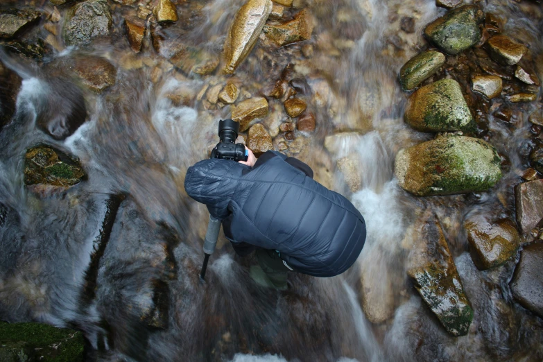 someone with a camera is sitting in the rocks