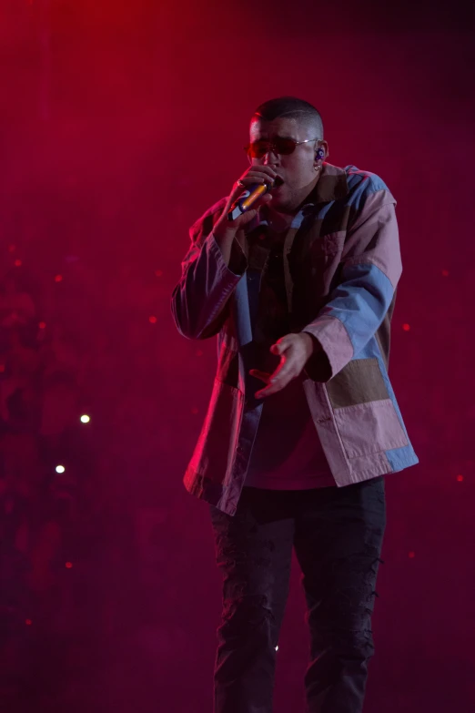 a man with sunglasses on singing into a microphone